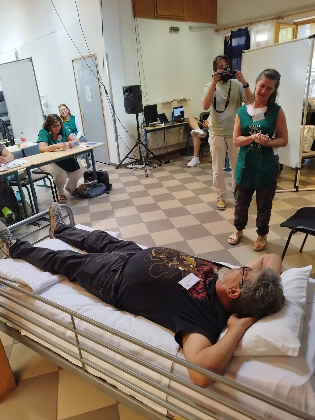 Egy önkéntes a segítő jelenlétet gyakorolja a kórházi ágy mellett